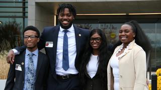 Four Saint Joseph's students standing in front of the Everest Insurance office