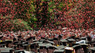 Red confetti falling over top of students in their caps and gowns