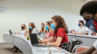 College students with masks in a classroom.