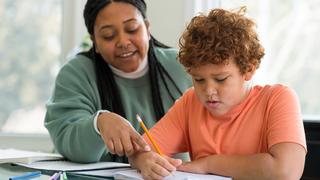 Teacher working with elementary age student on an assignment