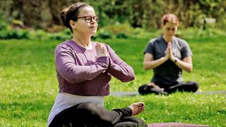 Two women doing yoga outside