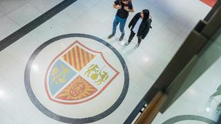Two students walk near the seal on the floor of mandeville hall
