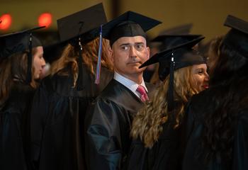 Michael J. Jordan in a black cap and gown surrounded by classmates at the Lancaster Commencement Ceremony