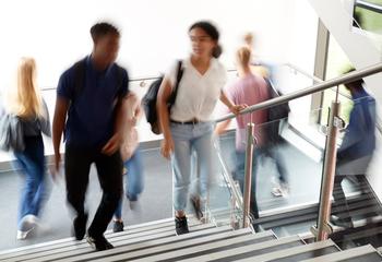 Motion blur shot of high school students walking on stairs between classes
