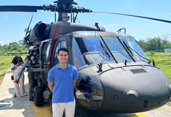 Caleb Datto standing in front of a helicopter 