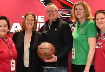 Four women and one man holding basketball in group photo for new Saint Joseph's and PFCU partnership