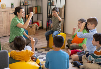 female sign language teacher teaching group of children in class
