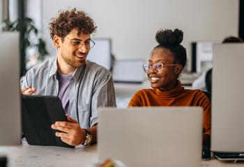 Two young colleagues working together at modern office