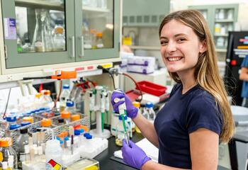 Abby Robinson, BS ’27, holding a test tube in a lab