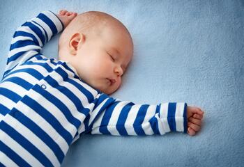 A baby asleep on a blue sheet