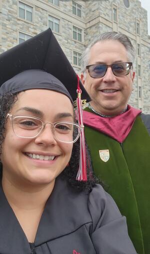 Nadia Reyes in regalia standing next to her professor