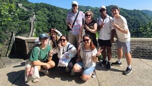 Students and faculty pose in front of the Great Wall of China.