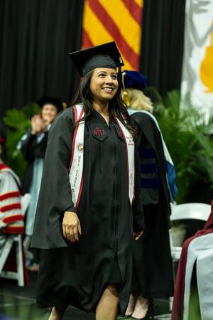 Magaly Urban wallking in her regalia on stage