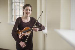 Erin Gartland '17 holds a violin and bow