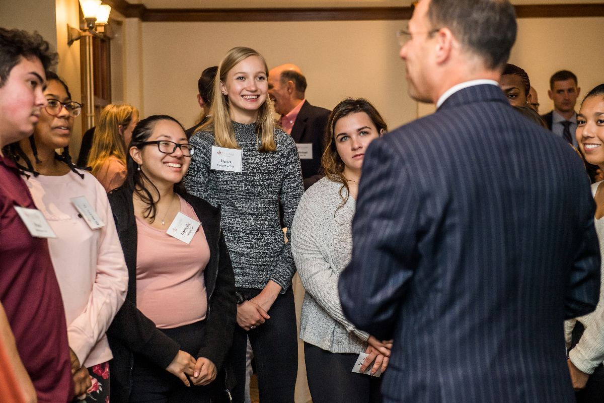 Students stand in a semi-circle, chatting with Shapiro.