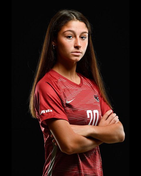 Danielle Stuart stands with her arms crossed in her soccer uniform