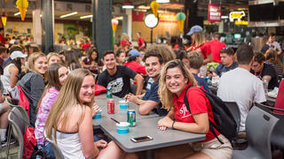 Students smile at a dining table