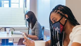 Saint Joseph's University student wearing a mask sitting at Saxbys