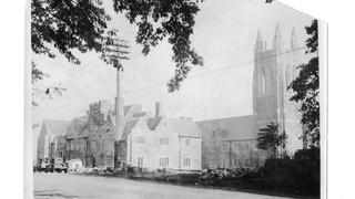 Exterior view of Barbelin building from City Avenue near end of construction with two automobiles in front 1927