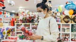 Woman in face mask shopping for Christmas ornaments