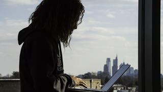 Student profile with the Philadelphia skyline in the background.