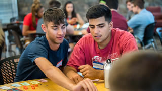 two students play a boardgame