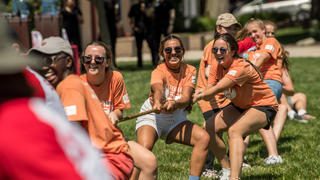 Students laugh while playing tug of war