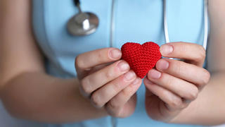 health care worker holding a small knit heart