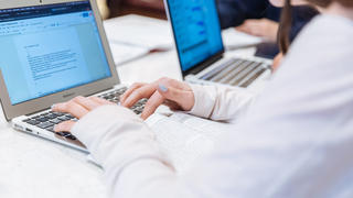 close up of hands typing on a keyboard