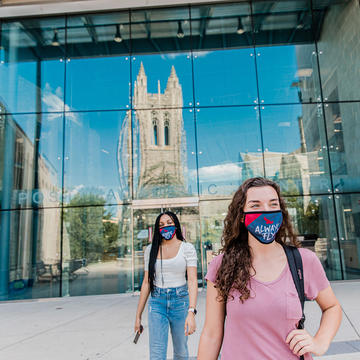 Saint Joseph's University students walking on campus next to the library wearing masks and practicing safe distancing