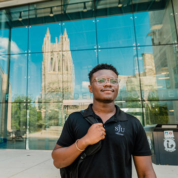 Student walking out side the library at Saint Joseph's University.