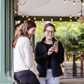 Saint Joseph's University students on campus looking at a cellphone.