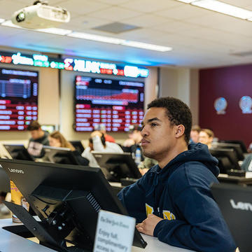 Student at desk in Haub School's Wall Street Trading Room