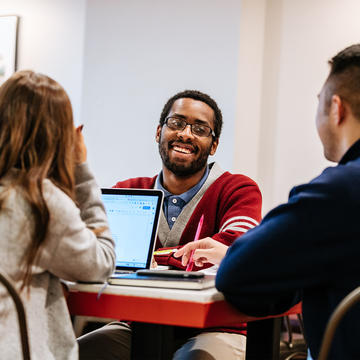 Saint Joseph's University students studying and talking in Drexel Library.