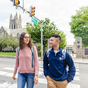 two students cross City Ave chatting