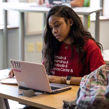 saint joseph's university student on her laptop inside a classroom