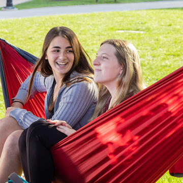 two students sitting on a hammock