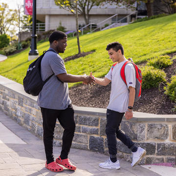 two saint joseph's university students shaking hands