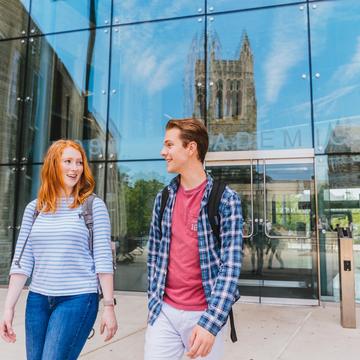 Two students walk in front of the library