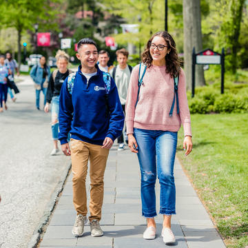 Students walking outside next to Regis Hall at Saint Joseph's University.