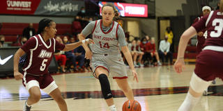 Saint Joseph's University student-athlete Katie Jekot dribbling the basketball during a game.