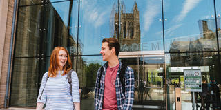 Saint Joseph's University students walking on campus next to the library.