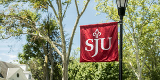 Red banner flag with the SJU on Lapsley Lane