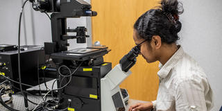 student looking into a microscope