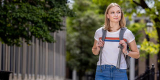 saint joseph's university student wearing a backpack and walking on campus