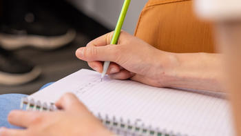 Student writing in a notebook