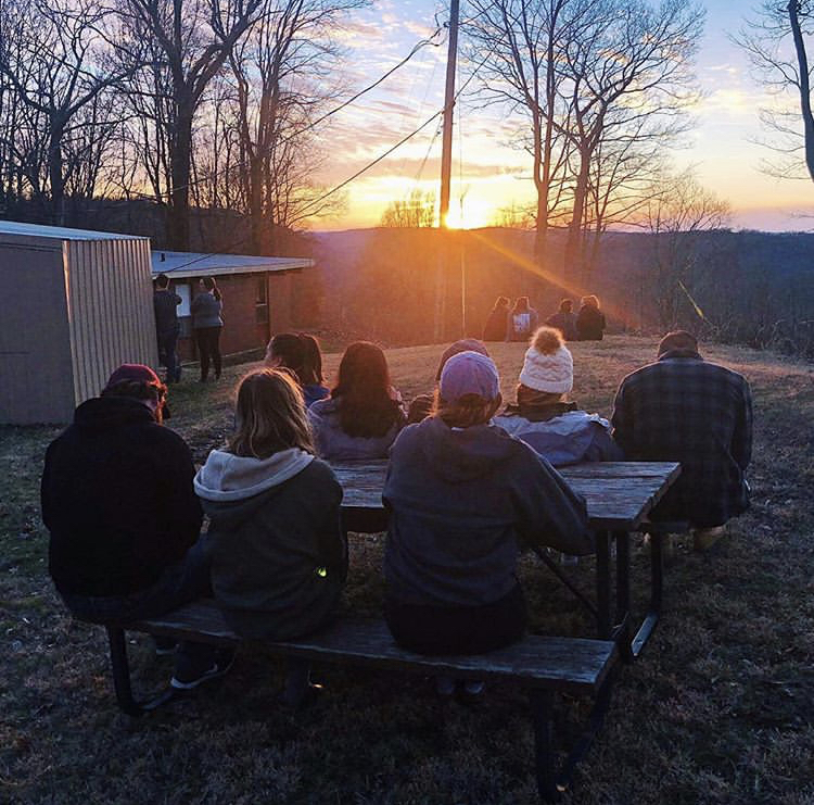 Students sitting down and admiring the sunset