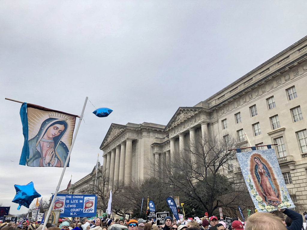 A parade of people holding banners