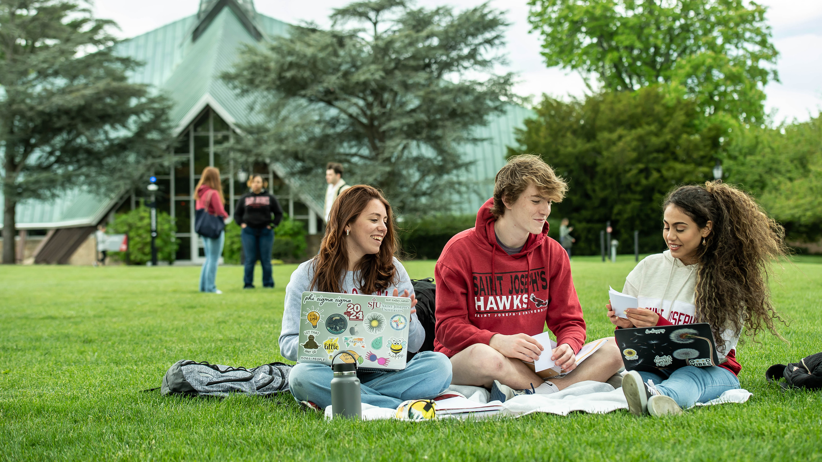 Saint Joseph's University Students outside Foley sitting on the grass chatting