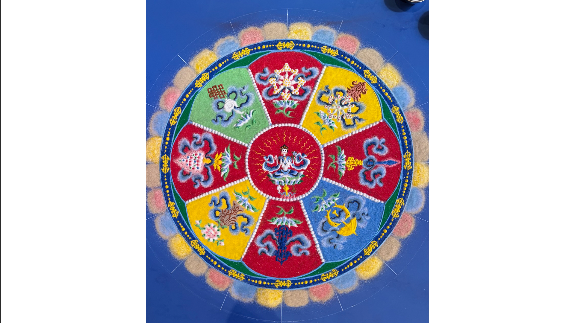 A sand mandala in progress by Losang Samten. This mandala is the Wheel of Compassion.